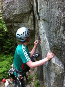 Christina places a cam in a vertical crack to build a trad anchor.