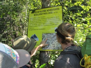 Alex and Elliott are debating whether or not to believe the “You Are Here” marker on this erroneous map at the start of the logging road