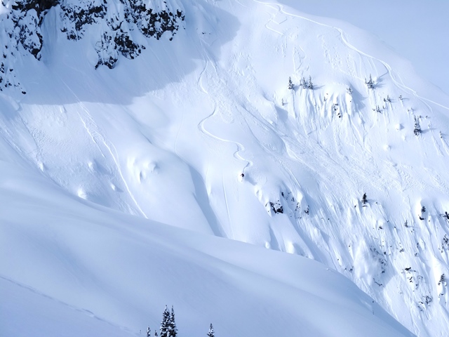 Unknown splitboarder in some serious terrain. He hucked a cliff just below, after this picture was shot. Photo Elliott Skierszkan.