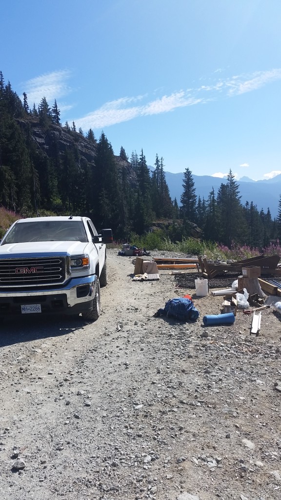 The beast of a truck and the outhouse materials being stacked on the cargo nets. 