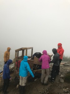 Rob and George both under the pedestal trying to make the liquid waste collector fit onto the structure. Cassandra in the light accurately depicts how cold and wet everyone it through her stance. 