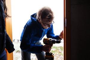 Alastair and Haley drilling holes in the frame so that the weather-stripping could be attached. 