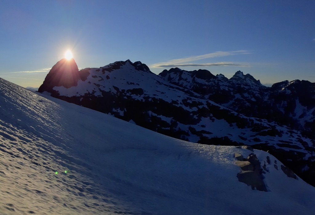 Sun marking the summit of Sharkfin Peak. Middle Finger is the highpoint at the far (right) end of the divide