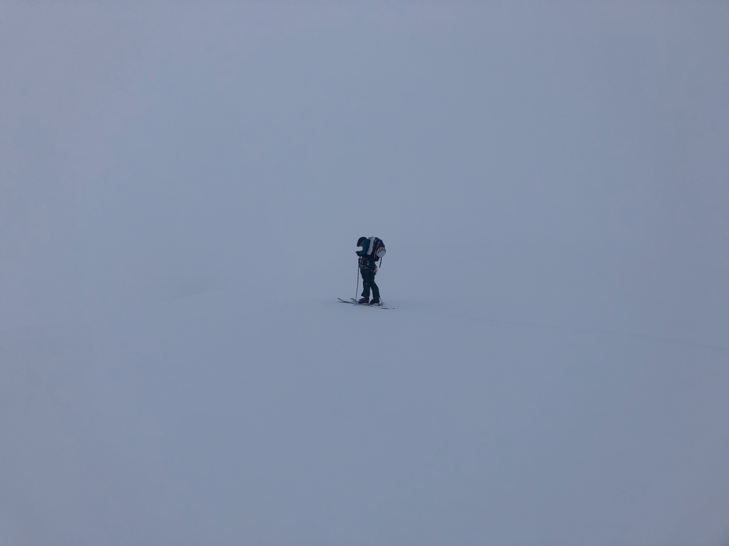 Alex, currently socked in by clouds part way up Nch’kay, checking his maps to help decide on our next moves.